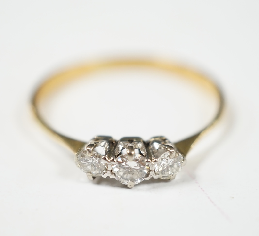 A yellow metal and three stone diamond set ring, size V, gross weight 2.4 grams. Condition - fair